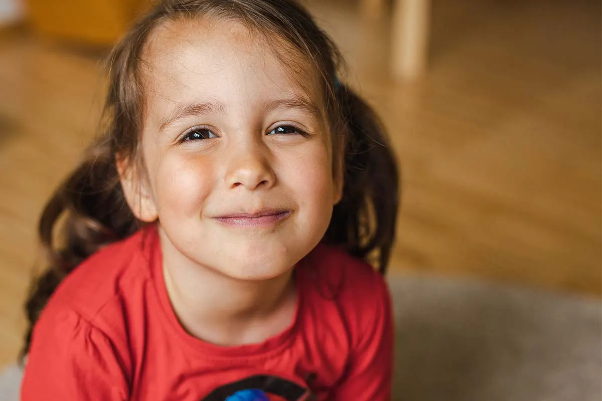 Mädchen mit Zöpfen lächelt in die Kamera