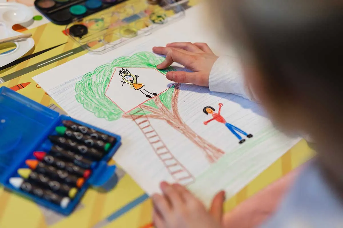 Kind malt Bild von Baumhaus